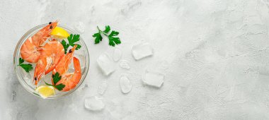 Gri arka planda buzlu, limonlu ve maydanozlu karidesler. Yukarıdan, boşluğu kopyala.