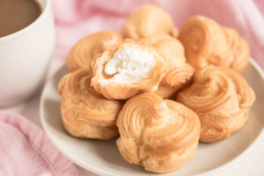 Bir fincan kahve ile profiterol. Beyaz arka plan. Sabah kahve. Kahve ile ihale kompozisyon