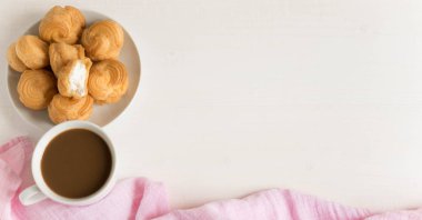 Bir fincan kahve ile profiterol. Beyaz arka plan. Sabah kahve. Kahve ile ihale kompozisyon