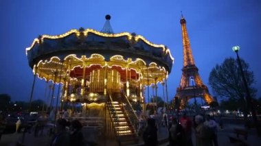 Alacakaranlıkta Eyfel Kulesi 'nin altındaki Atlıkarınca, Paris Fransa 