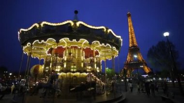 Alacakaranlıkta Eyfel Kulesi 'nin altındaki Atlıkarınca, Paris Fransa 