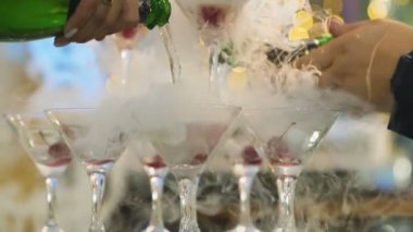 Ağır çekim şampanya partisi için sıvı azot ile gözlük içine dökme garson