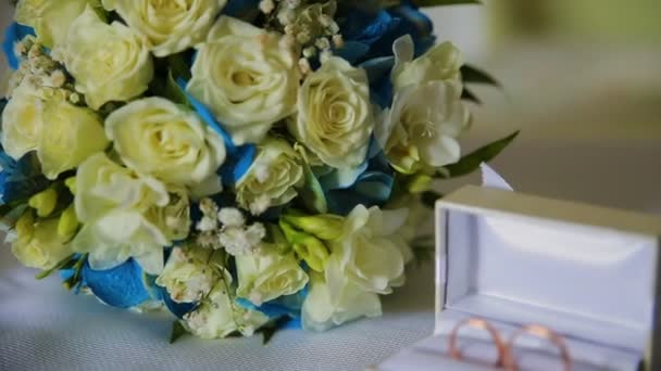 Golden wedding rings hanging on branch on the green background — Stock Video