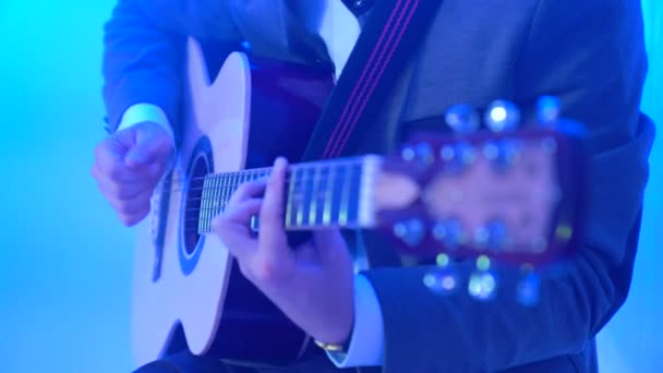 Guitarrista 4k toca la guitarra acústica en el escenario del club nocturno, destellos de luces de color — Vídeo de stock