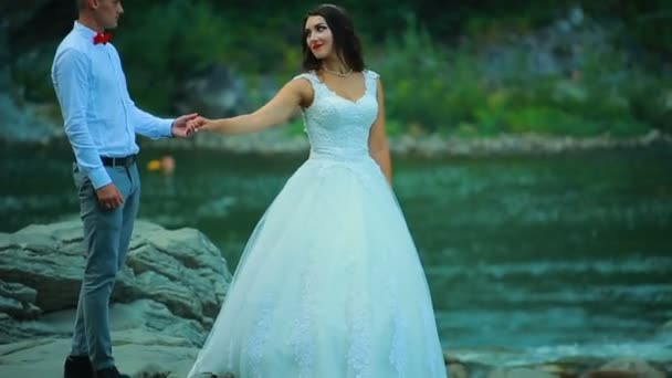 Casal andando perto do rio da montanha em um dia de primavera — Vídeo de Stock