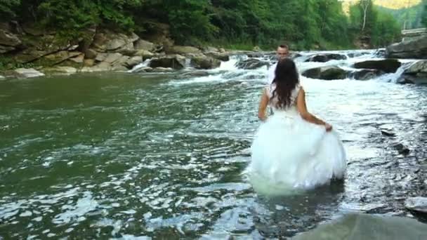 En cámara lenta. Pareja feliz en el amor tienen una alegría durante el paseo cerca del río. 100fps — Vídeo de stock