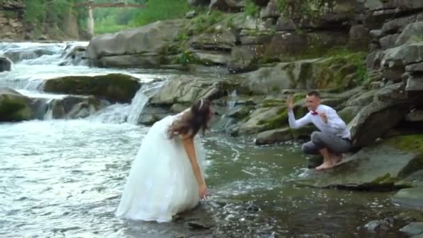 スローモーション。幸せなカップルの愛の川の近くの散歩中に喜びがあります。100 fps — ストック動画
