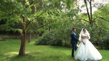 Yürüyüş ve şehir parkında el ele tutuşarak kadın ve iki erkek. Ağır çekim