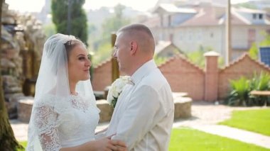 Güneşli park boyunca yürüyüş ve şefkatle öpüşme sırasında elele çift