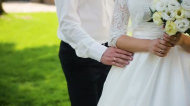 Güneşli park boyunca yürüyüş ve şefkatle öpüşme sırasında elele çift