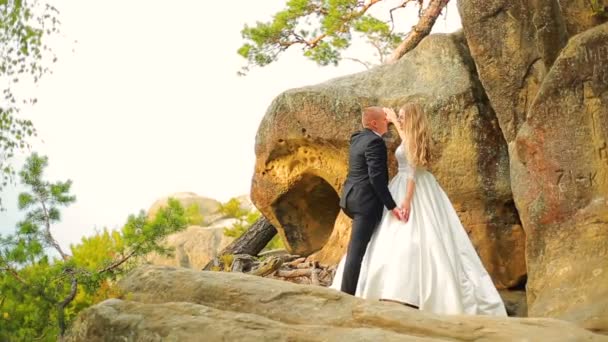 Paar klettert auf den Felsen und bewundert den Sonnenaufgang, den Sonnenuntergang — Stockvideo