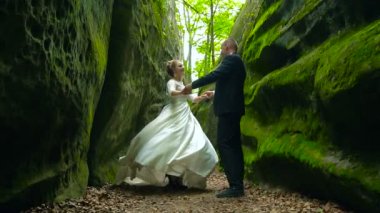 Kaya tırmanışı ve güneşin doğuşunu hayran yaşlı aktif çift gün batımı. İskandinavya yatay, deniz ve çam ağaçları. Ağır çekim Fullhd