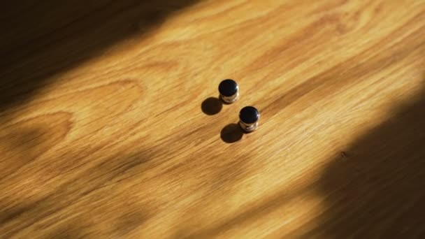 Cufflinks at wooden background — Stock Video