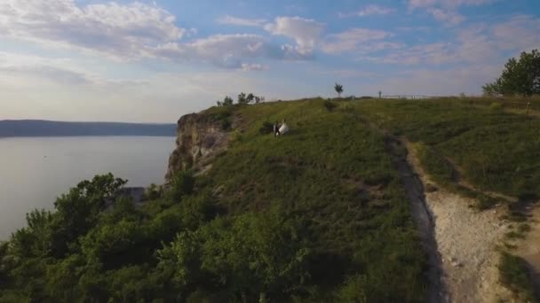 Imagens de drones aéreos 4K de casal no penhasco. Incrível conceito de viagem — Vídeo de Stock