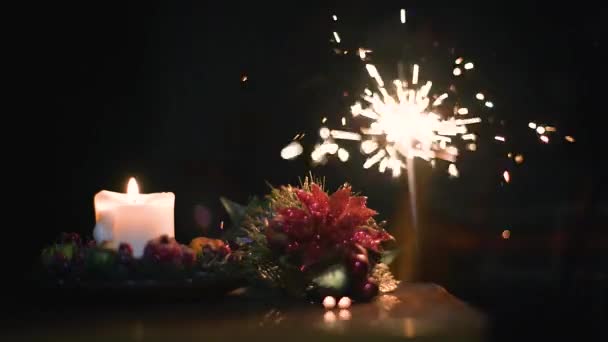 Kerst gele kaars, Bengalen vuur en decoratie op een donkere achtergrond — Stockvideo