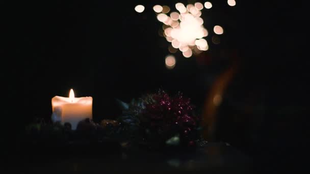 Vela amarilla de Navidad, fuego de bengala y decoración sobre un fondo oscuro — Vídeos de Stock