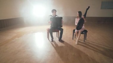 Siyah akordeon ve bandura enstrüman çalan iki müzisyen.
