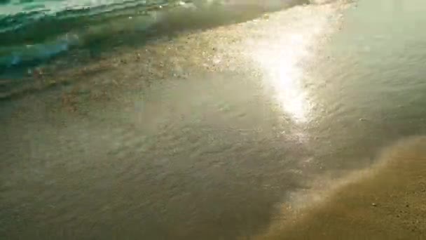 4k Wellen am Strand bei Sonnenuntergang, Sonnenlicht reflektiert auf der Wasseroberfläche — Stockvideo