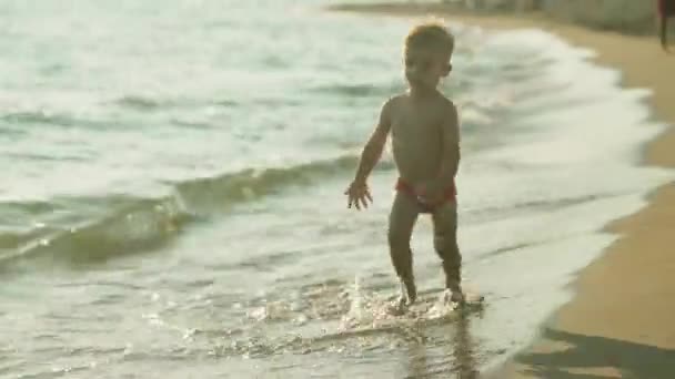 Primo piano vista di piccole gambe carine di bambino in acqua di mare blu scintillante 4k — Video Stock