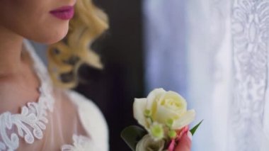 Perdeleri açan ve pencereden dışarı bakan kadın.