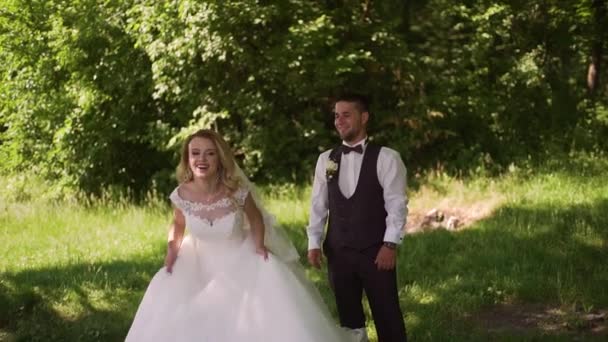 Groom vient à charmante mariée blonde avec bouquet derrière elle. Mouvement lent 