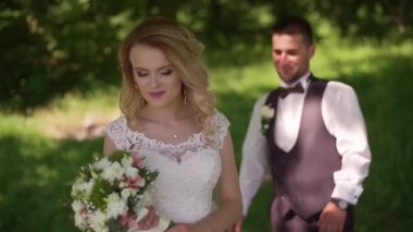 Damat arkasında buket ile büyüleyici sarışın gelin geliyor. Yavaş çekim
