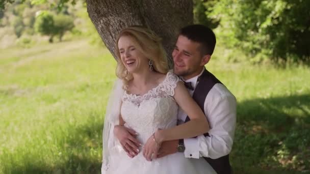 Groom comes to charming blonde bride with bouquet behind her. Slow motion — Stock Video