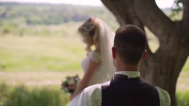 Brudgummen kommer till charmig blond brud med bukett bakom henne. Slow motion — Stockvideo