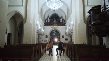 Çift müzisyenler Katolik kilisesinde bandura ve akordeon çalıyor
