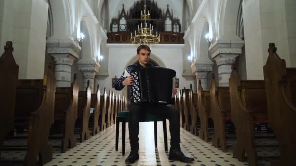 Uma musicista está tocando acordeão na igreja antiga. Fechar interior — Vídeo de Stock