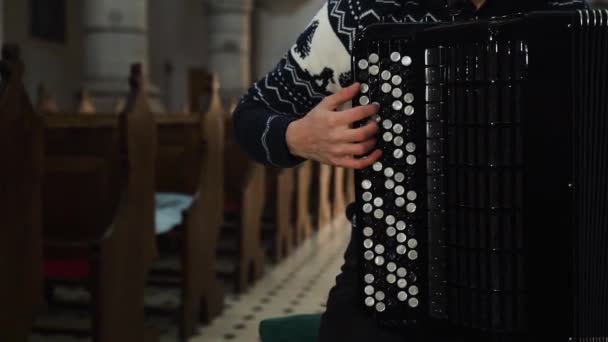 Женщина-музыкант играет на аккордеоне в старой церкви. Закрыть в помещении — стоковое видео
