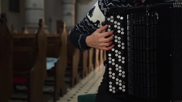 Uma musicista está tocando acordeão na igreja antiga. Fechar interior — Vídeo de Stock