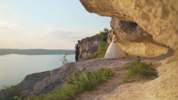 Ένα ζευγάρι περπατάει στα βράχια του ωκεανού, παίρνει τη θέα μαζί. Αργή κίνηση — Αρχείο Βίντεο