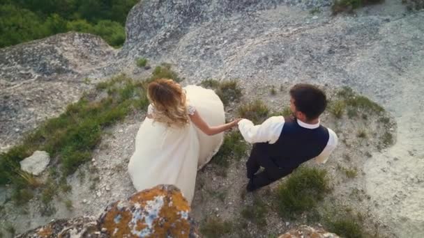 Couple in love a walk among the coastal stones on the seashore. Slow motion — Stock Video