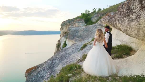 Couple amoureux d'une promenade parmi les pierres côtières sur le bord de la mer. Mouvement lent — Video