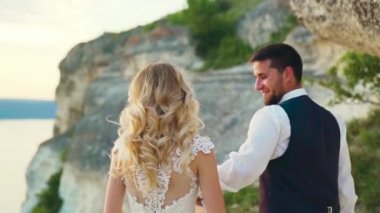 Aşık çift deniz kıyısında kıyı taşları arasında bir yürüyüş. Yavaş çekim