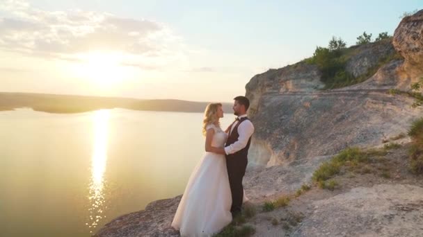 Um casal caminha até aos penhascos oceânicos e vê-os juntos. Movimento lento . — Vídeo de Stock