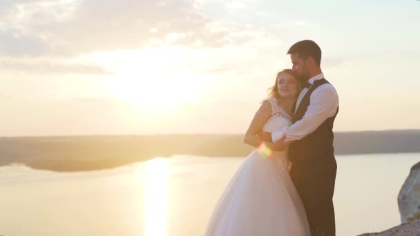 Um casal caminha até aos penhascos oceânicos e vê-os juntos. Movimento lento . — Vídeo de Stock