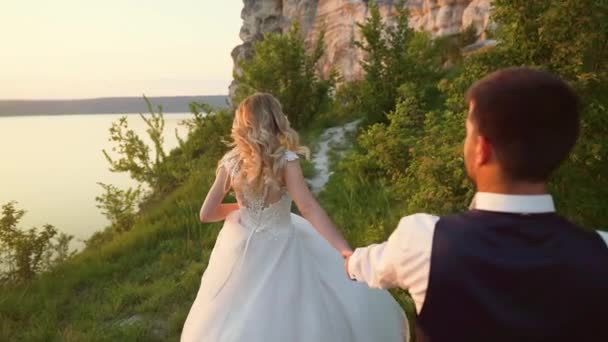 Couple amoureux d'une promenade parmi les pierres côtières sur le bord de la mer. Mouvement lent — Video