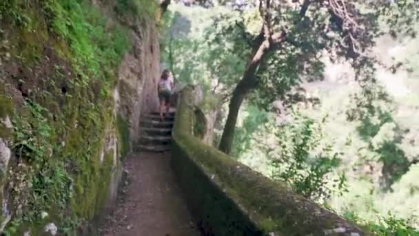 Η ενήλικη γυναίκα τουρίστρια περπατάει μόνη της μέσα σε σπηλιά με κολώνες. Αργή κίνηση — Αρχείο Βίντεο