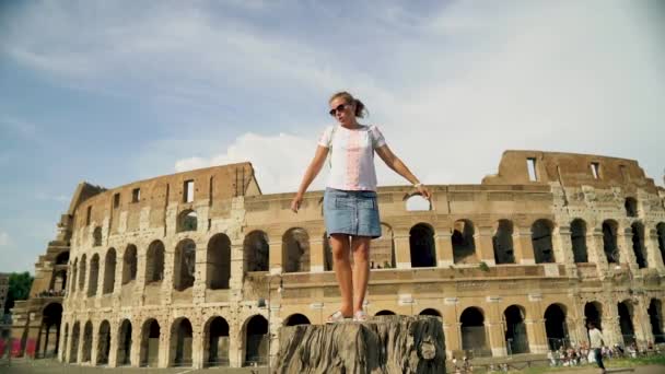 Hermosa turista posa cerca del coliseo romano. Movimiento lento — Vídeos de Stock