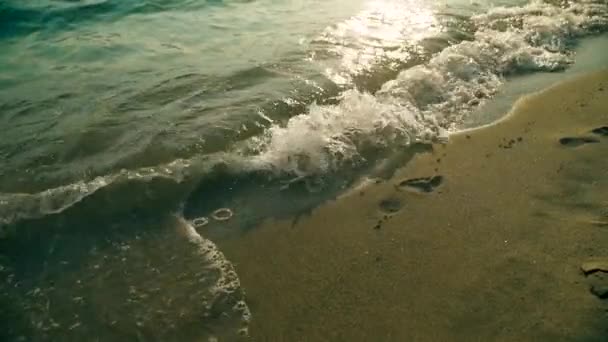 日没時のスローモーションで砂浜を洗う海の波のクローズアップ — ストック動画