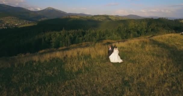 La coppia in piedi sulla pittoresca montagna al sorgere del sole bckg 4k aerea — Video Stock