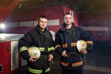İtfaiyeci (itfaiye) eylem daimi bir firetruck yakınındaki. Acil durum Emanet. Koruma, tehlikeden kurtarmak.