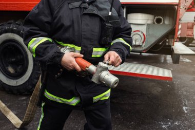 İtfaiyeci (itfaiye) eylem daimi bir firetruck yakınındaki. Acil durum Emanet. Koruma, tehlikeden kurtarmak.