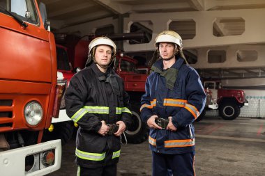 İtfaiyeci (itfaiye) eylem daimi bir firetruck yakınındaki. Acil durum Emanet. Koruma, tehlikeden kurtarmak.