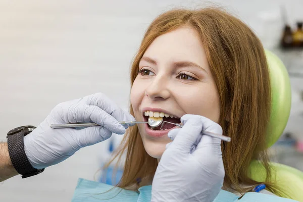 Dentist examining girl\'s teeth in clinic. Dental problem. Healthy Smile.