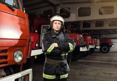 İtfaiyeci (itfaiye) eylem daimi bir firetruck yakınındaki. Acil durum Emanet. Koruma, tehlikeden kurtarmak.