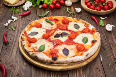 ahşap arka plan üzerinde rustik İtalyan pizza Margarita mozzarella peyniri, domates ve fesleğen yaprakları