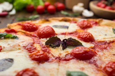 ahşap arka plan üzerinde rustik İtalyan pizza Margarita mozzarella peyniri, domates ve fesleğen yaprakları